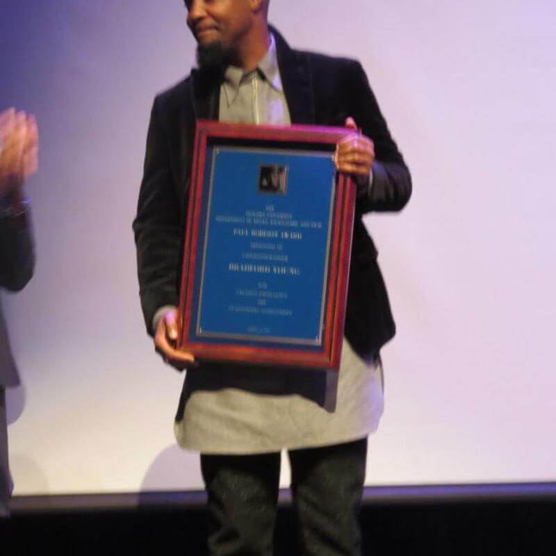 Bradford Young holding award at 2015 Paul Robeson Student Awards