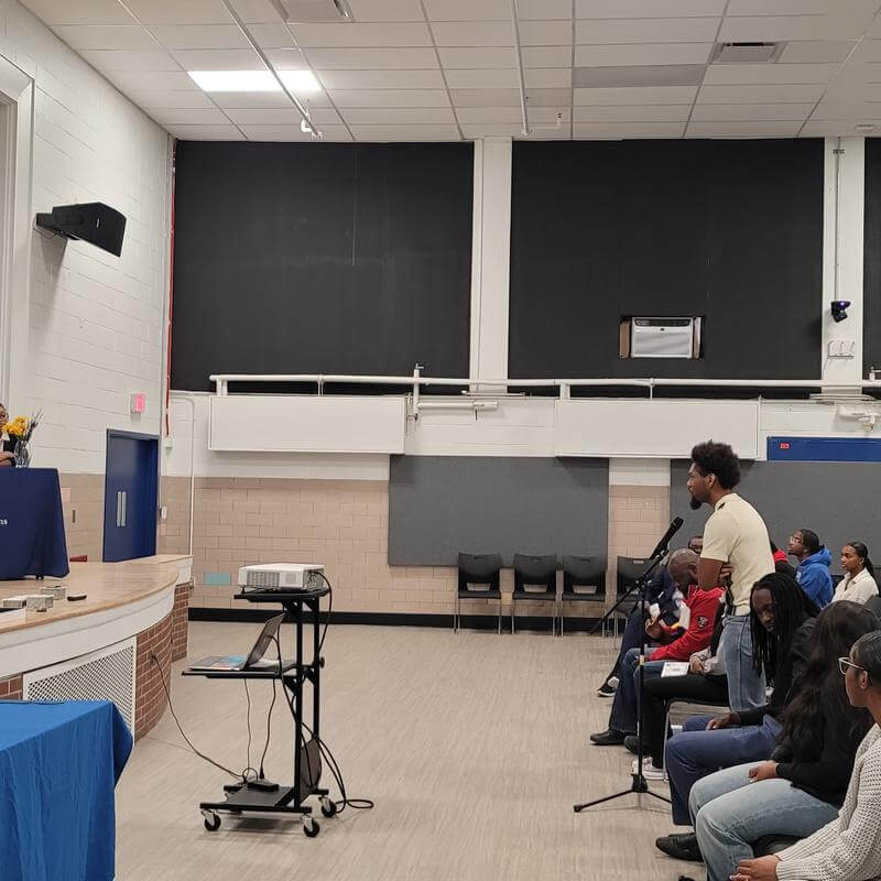 AHP HU student speaks at mic in front of Annenberg Students on stage