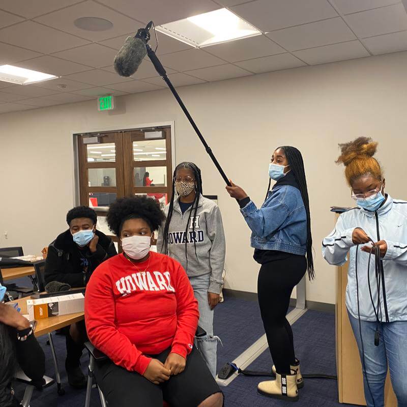 HU audio students wearing masks and holding mic