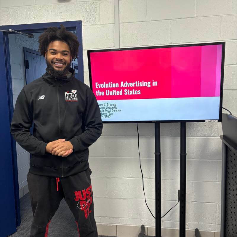 Annenberg Honors Program HU Student smiles and in front of Evolution of Advertising in the United States