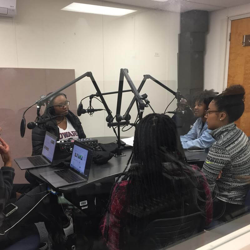 audio production students in group seated with mics