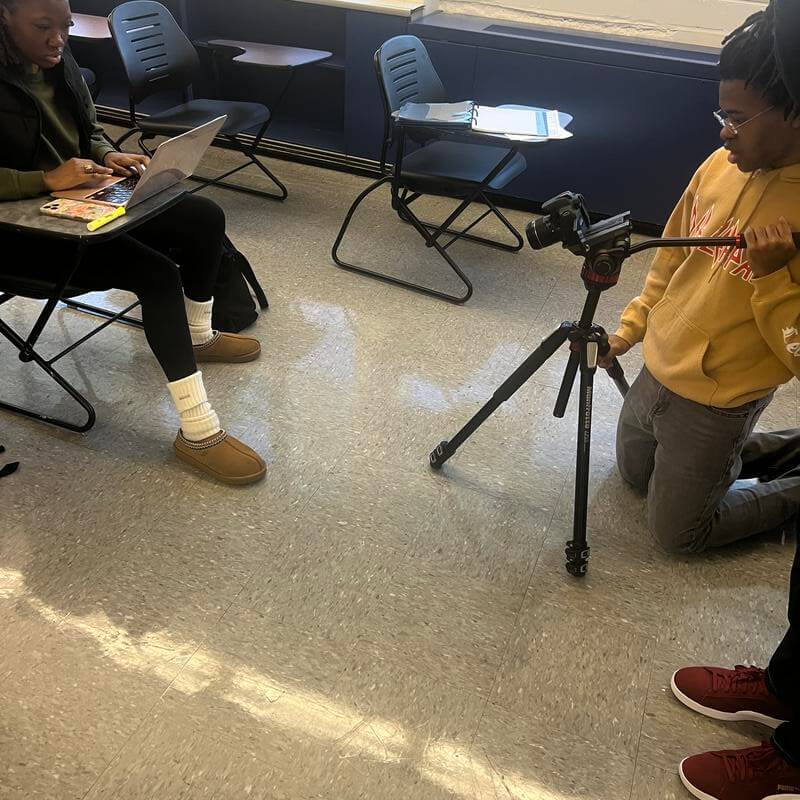 A Howard University Film and TV student with camera in classroom