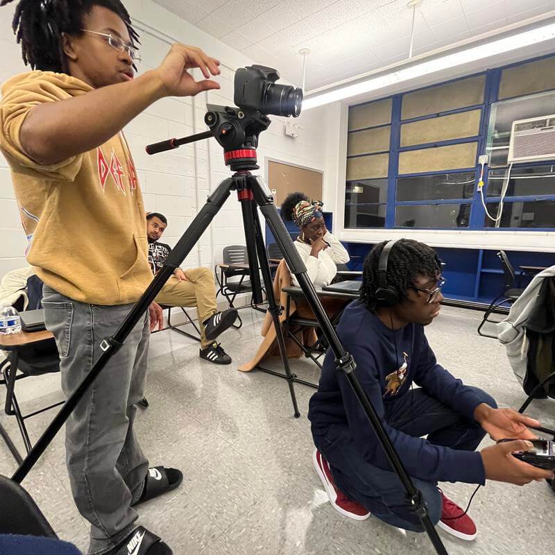 Howard Student with camera in classroom setting