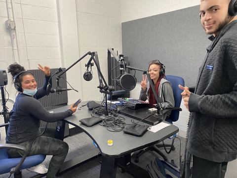 HU audio production students smiling on set with microphones