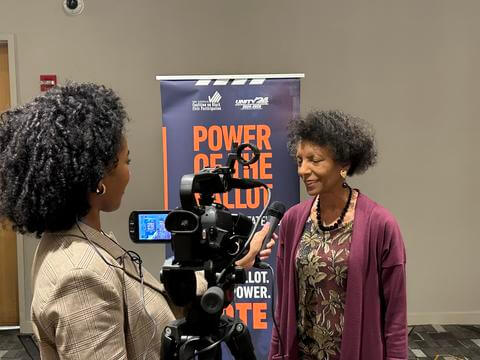 Howard University student holding a microphone and conducting interview