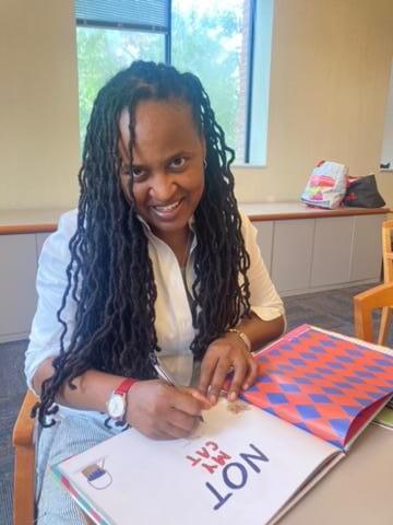 Portrait of Stacey Patton signing a book