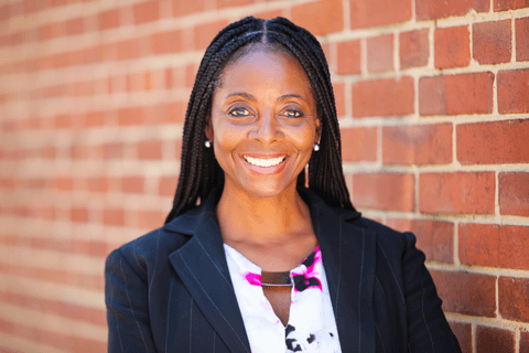 professor Jennifer Thomas headshot with brick wall